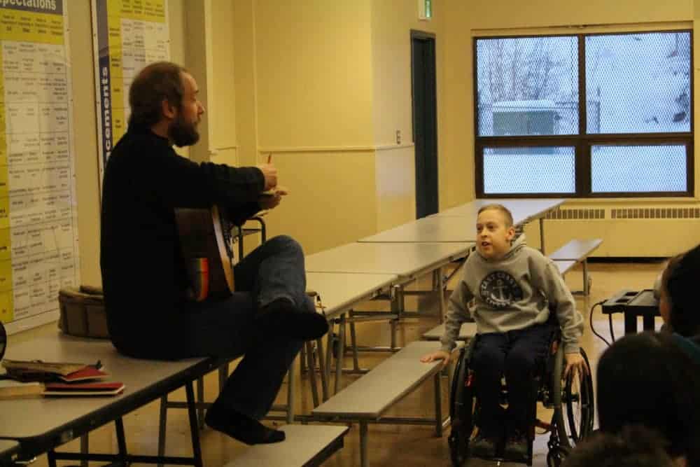 January 11, 2019 Folk singer Craig Cardiff jots down some personal facts about William McDonald Middle School student Riley Olefort before singing a song about him during a songwriter workshop. Brett McGarry/NNSL Photo