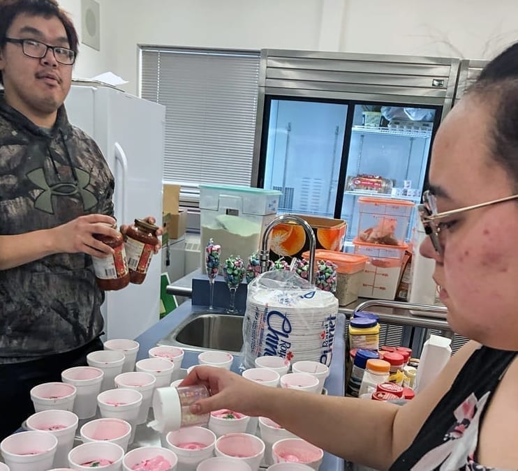 Shanae Piercey carefully sweetens the sweets as Wally Kalluk carefully guards the secret ingredients during a Valentine's Day fundraiser for the potential graduates at Jonah Amitnaaq Secondary School in Baker Lake on Feb. 14, 2019. Photo courtesy Olivia Ullyot