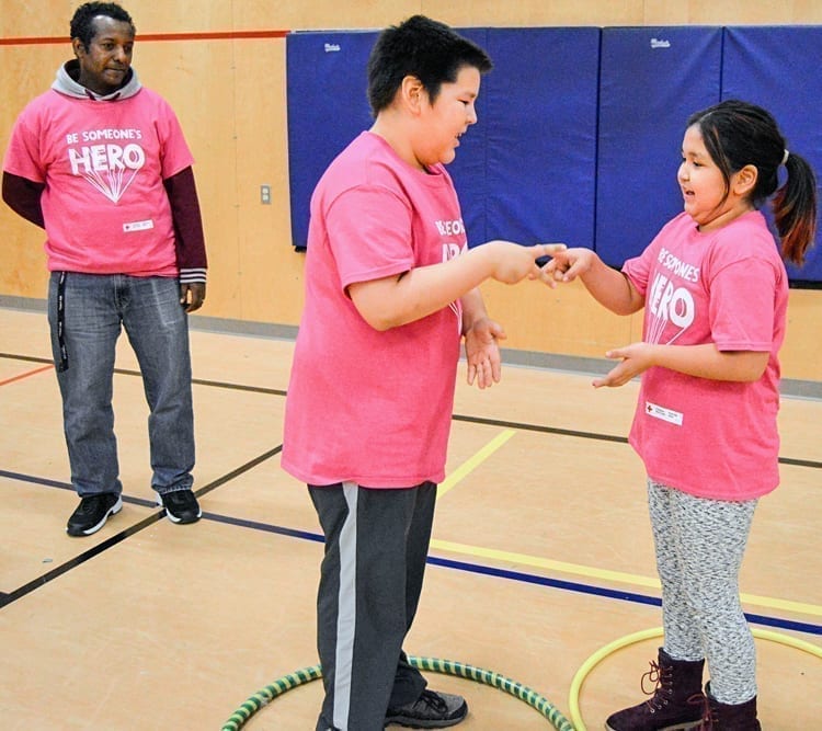 Teacher Alex Asfaw, left, follows along as students Austin Mullins and Bertha-Grace Aggark play a game of rock-paper-scissors during Pink Day activities at Victor Sammurtok School in Chesterfield Inlet on Feb. 27, 2019. Photo courtesy Victor Sammurtok School