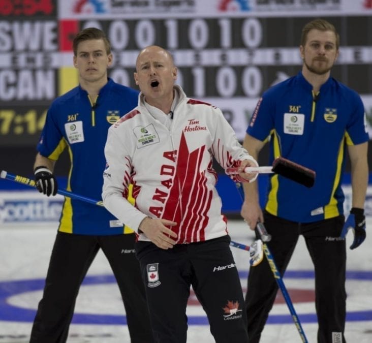 Kevin Koe grimaces as he watches a shot while Sweden's Christoffer Sundgren, left, and Rasmus Wrana look on behind during the final of the World Men's Curling Championship in Lethbridge, Alta., on Sunday evening. Michael Burns/World Curling Federation photo