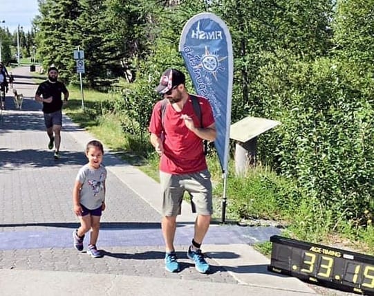 Sanaa Doherty, left, and her dad, Shaun Doherty, cross the finish line together in the 3-km family fun run portion of the Fun Run/Walk Challenge's second event at Somba K'e Park on June 30. photo courtesy of Cameron Twa