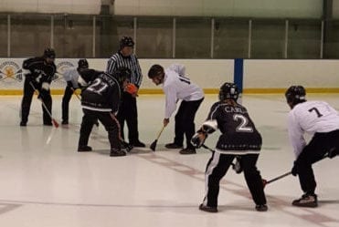 Yellowknife Coyotes forward Jeremy Ouillette (white #10) awaits the faceoff against a Japanese opponent during mixed division play at the 2016 World Broomball Championships in Regina. The Coyotes would go on to win bronze that year. photo courtesy of Aki Iwase