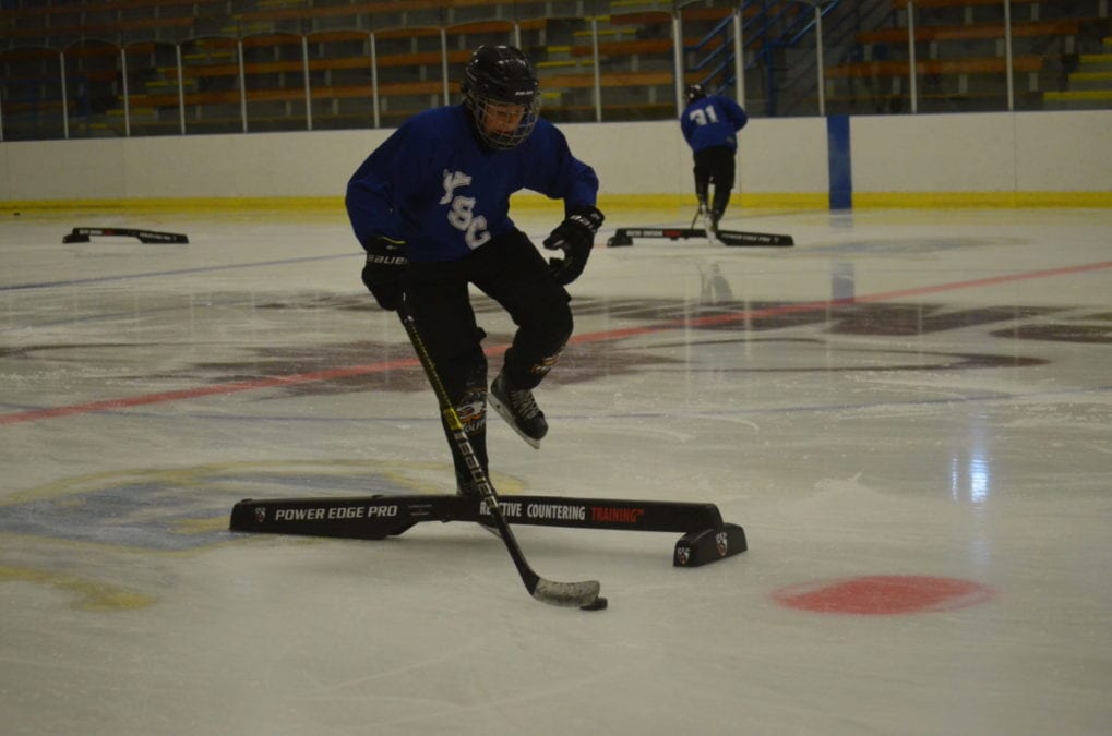 Ryder Wicks leaps over the obstacle during a puckhandling drill as part of the Yellowknife Sporting Club's opening weekend of its hockey camp at the Yk Community Arena on Saturday. James McCarthy/窪蹋勛圖厙 photo
