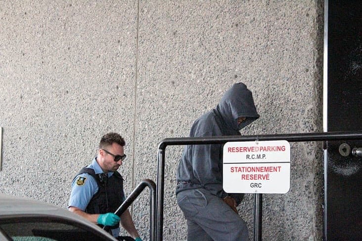 Brendan Burke/NNSL photo Wilfred Abraham, 54, covers his face as he enters a Yellowknife courthouse in handcuffs Thursday. Abraham has been charged with second-degree murder for the death of 48-year-old Ralph Sifton.