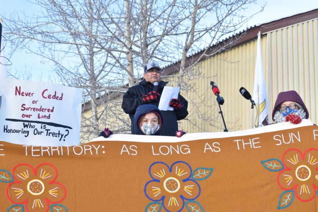 Karen Martin, front, and Margaret Erasmus hold up a banner as Edward Sangris, Dettah chief of the Yellowknives Dene First Nation speaks at a demonstration at the Giant Mine site on Wednesday, where he renewed a call for an apology from the federal government and compensation for environmental damage from the mine. Blair McBride/NNSL photo