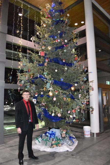 Frederick Blake Jr, speaker of the legislative assembly stands beside the 20-foot tall Christmas tree in the lobby of the assembly building, on Dec. 9. Blair McBride/NNSL photo