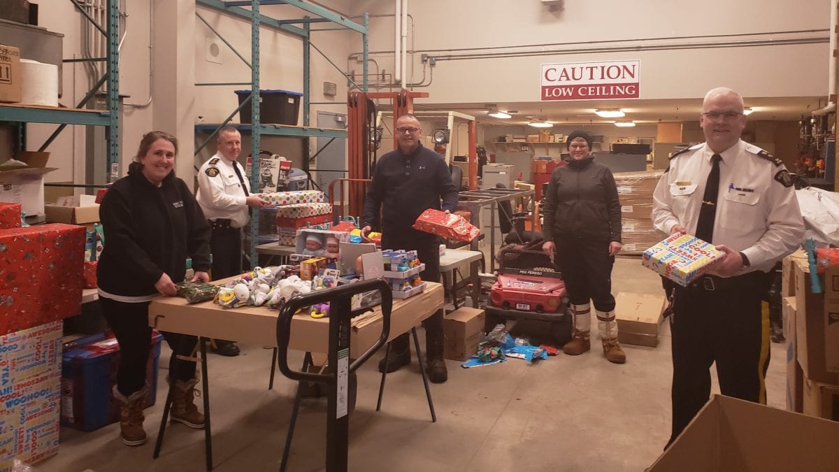 Cst. Heather Cosenzo, left, Commanding Officer Jamie Zettler, Insp. Dave Casey, Cst.  Michelle Steele and Superintendent Jeff Christie wrap presents while social distancing. NT RCMP image