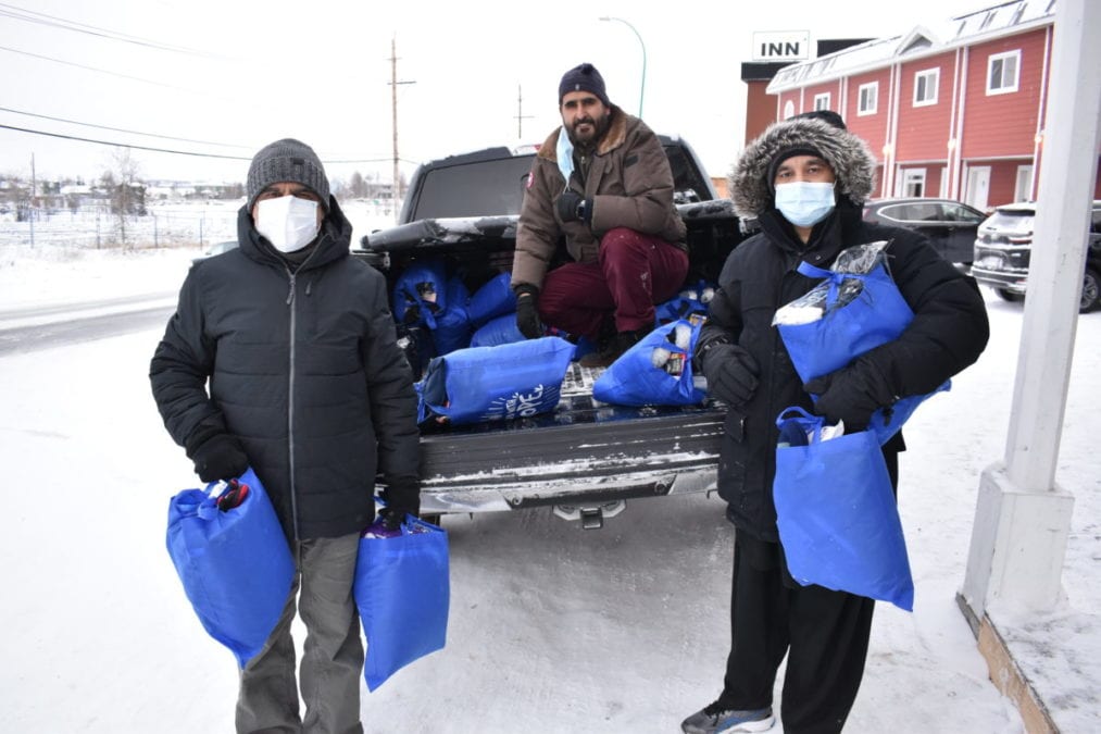 Zaka-Ullah, left, Nazim Awan, chair of the Islamic Centre of Yellowknife and Asif Mirza unload winter warmth kits at the Yellowknife Women's Society on Wednesday. Blair McBride/NNSL photo