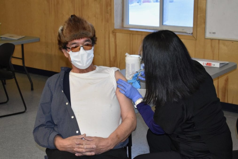 Wekweeti chief Charlie Football, left, receives his Covid-19 vaccination from nurse Lianne Mantla, in the Youth Centre, on Wednesday. Blair McBride/NNSL photo