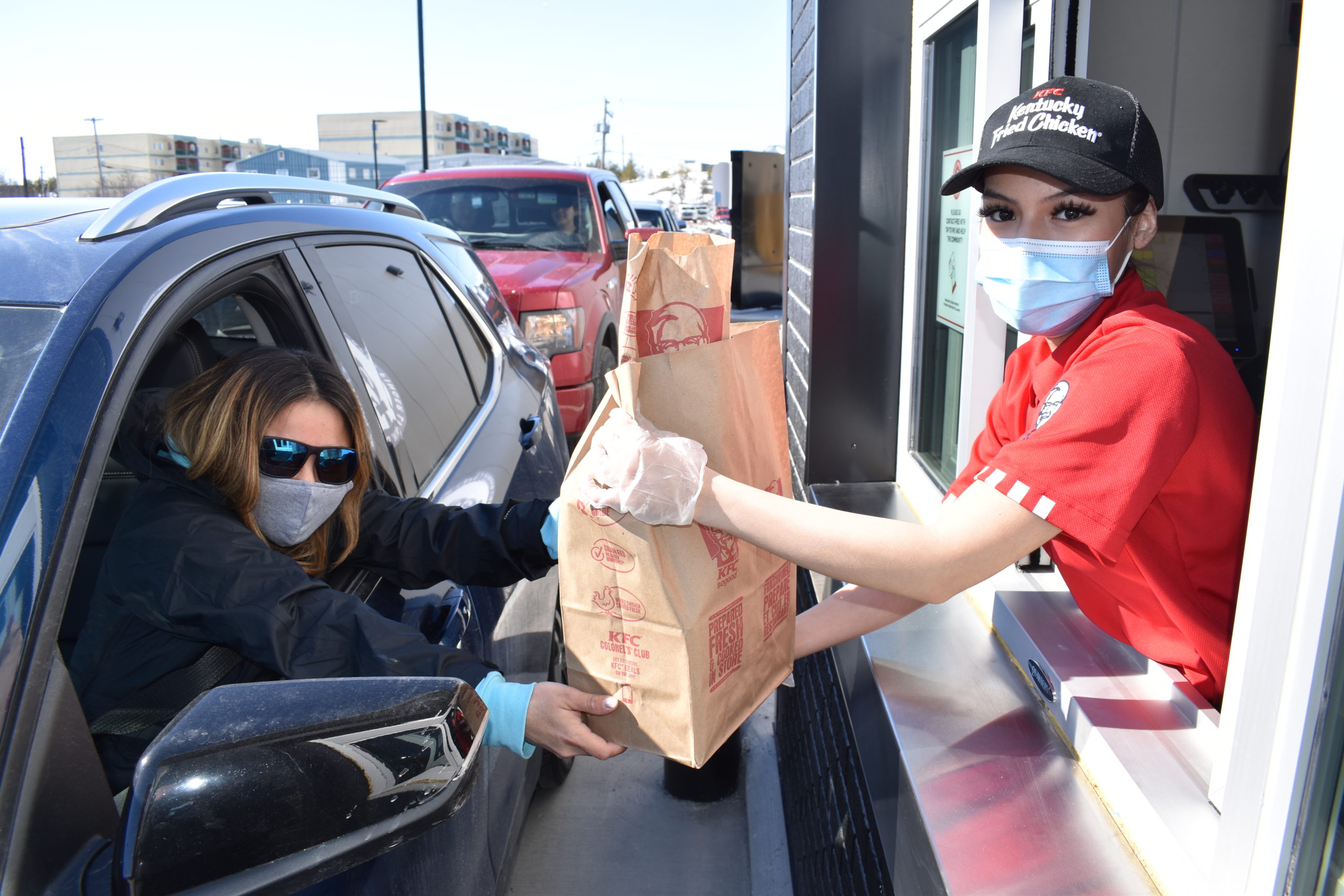 Karen Martin, left, receives her hot bag of chicken from attendant Kaya Goulet. "This is my first job ever," said Goulet. "Its a bit overwhelming but I know everyone in Yellowknife is really excited about this day." Blair McBride/窪蹋勛圖厙 photo