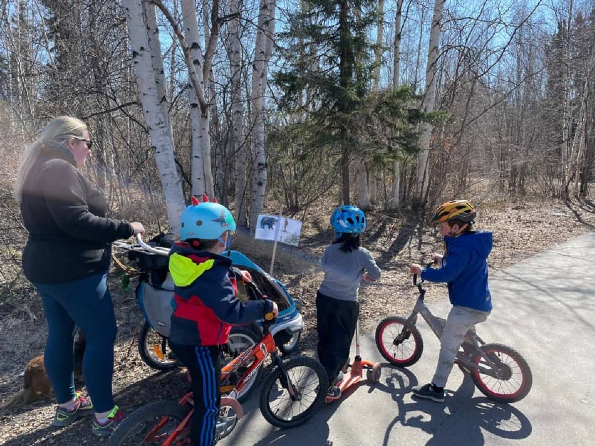 Betsy Lucko, left, Jack Nixon, Cassie Cott and William Mansfield read a page from Anna and the Bear during the story walk on May 21. photo courtesy of Kate Mansfield