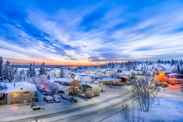 Sunrise over looking neighborhood in Yellowknife during winter with snow, road and clouds