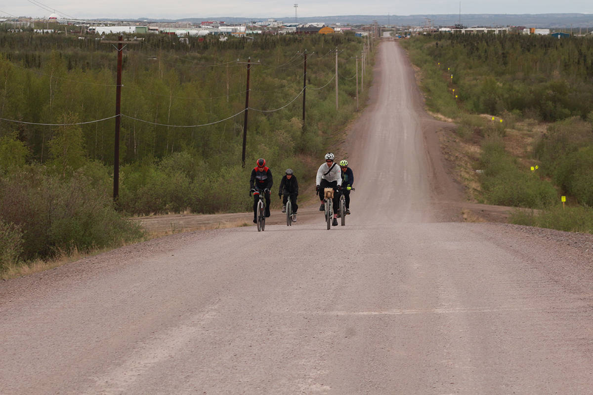 The first of many long climbs. Chris Bruckner, Jenna Wolki, Mike Lee and Mike Bodnar slog their way up the hill leading out of Inuvik and toward Tuktoyaktuk. Eric Bowling/窪蹋勛圖厙 photo