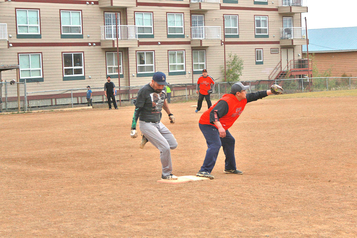 Charton Wolki snatches the ball just before Tyler Bain reaches first base. Slo-Pitch season in Inuvik wrapped up with a three-day tournament Aug. 20 to 22. Eric Bowling/NNSL photo