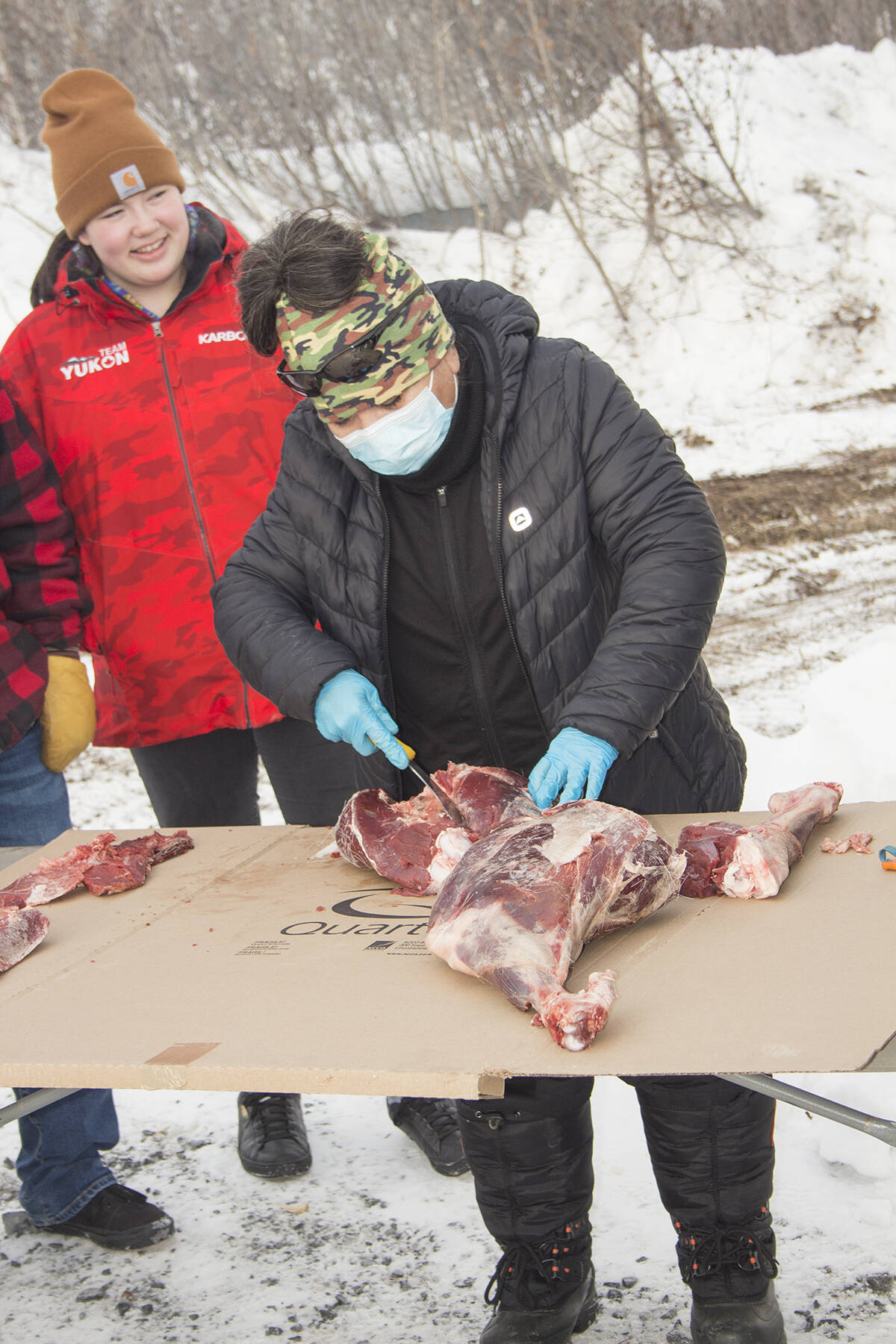 Liz Jerome cuts caribou into chunks as part of the Stewards on the Land workshop. The meat was cut into small bites for the youth to eat. Eric Bowling/NNSL photo