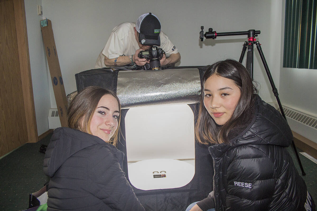 Alexandria Testart-Campbell and Reese Wainman glance back as Black Fly Studios owner Tony Devlin takes photos of handcrafted earrings. A total of 30 unique pairs of earrings are up for grabs in a MotherSA国际影视传媒檚 Day raffle to fundraise for Team Wainman. Eric Bowling/NNSL photo