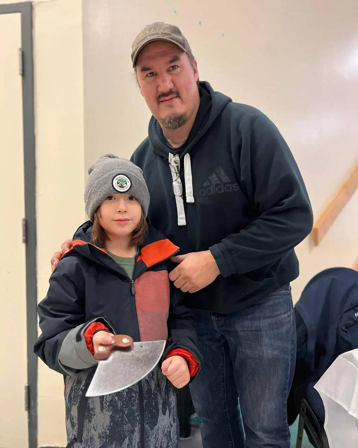 Our Youth of the Week is Noah Cormier, seen here with RKV Bladesmith Rory Voudrach. Noah has been participating in an on-the-land school program with his father, learning traditional survival methods. After watching others working with an ulu, Noah decided he wanted one himself and has been operating a lemonade stand and collecting bottles for the past several months to save up. He finally got his blade at the Christmas Craft Fair Nov. 25 to 27. Photo courtesy of Kimberlly Walters