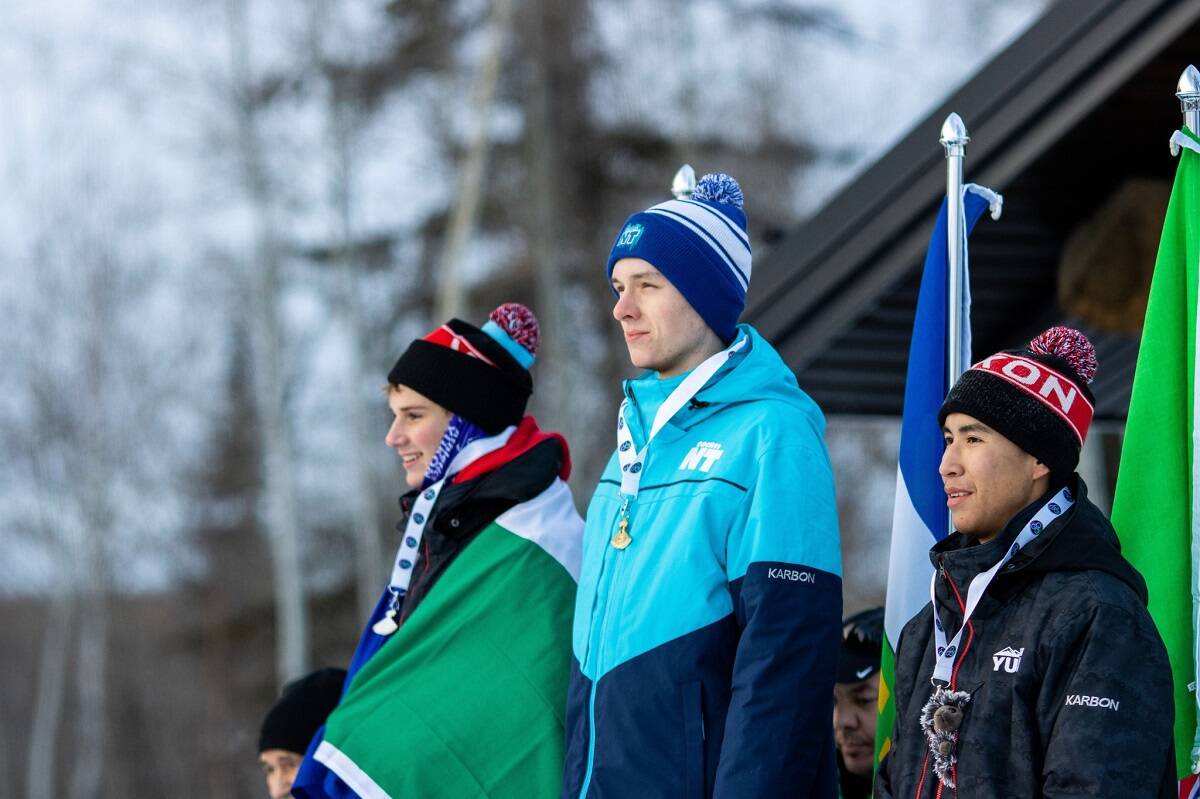 Gold medallist Alexander Fast, centre, listens to the national anthem during the ulu ceremony in snowshoeing on Monday. Photo courtesy of Team NT