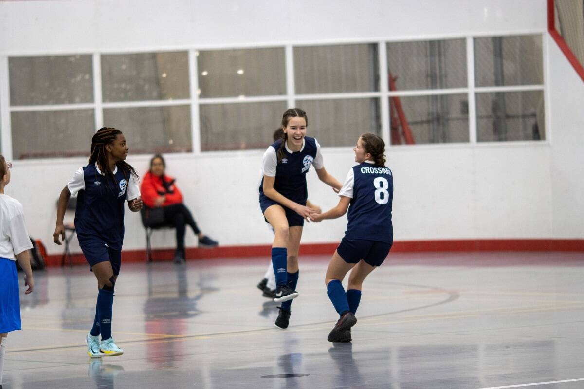 Emily Neglak-Voss, centre, celebrates with Ayanna Darku, left, and Evynn Crossman after scoring a goal during juvenile girls futsal action on Monday. Photo courtesy of Team NT