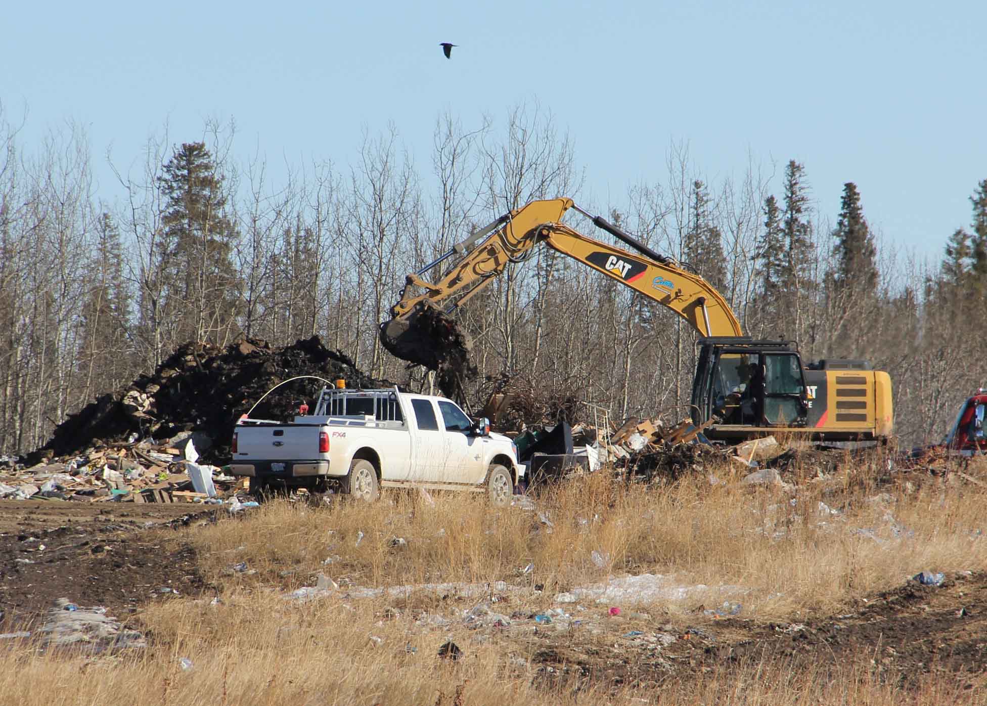The now extinuished fire at the landfill site will be costly for the Town of Hay River. The expenses - like for this excavator working on the almost-extinguished fire on March 22 - may approach $400,000. ºÚÁϳԹÏÍø file photo