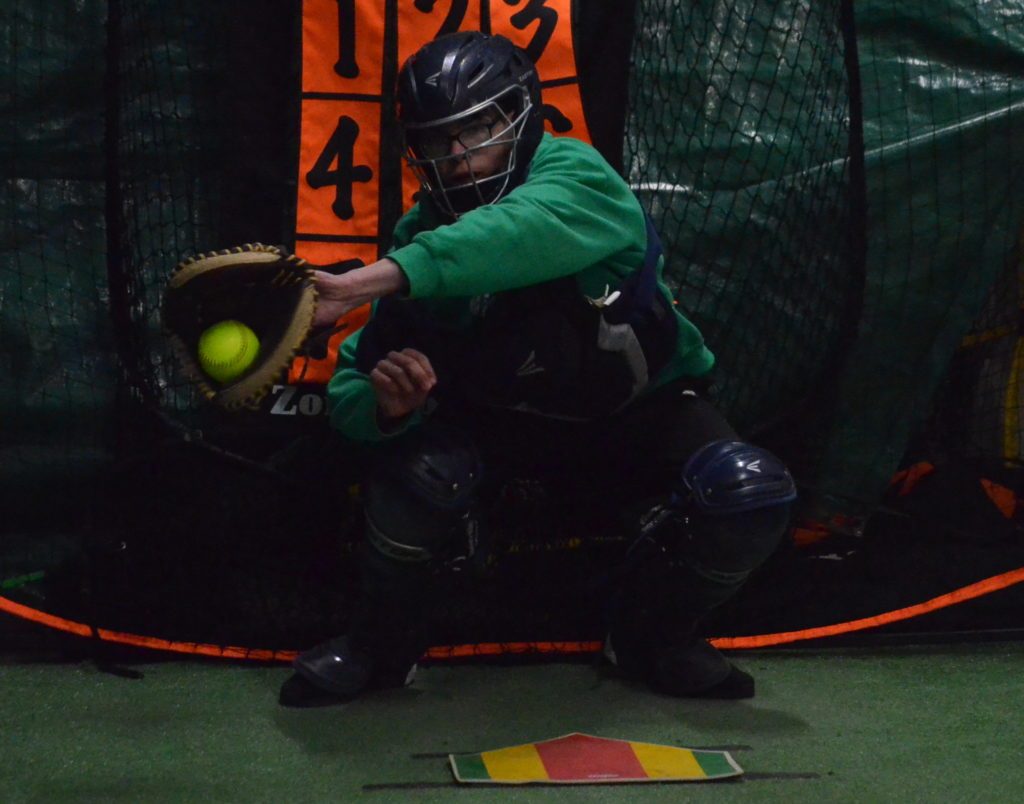 Rhys Robertson snags a pitch during a practice session at NWT Softball's temporary indoor facility at Pack Rat Storage on Wednesday evening. James McCarthy/NNSL photo