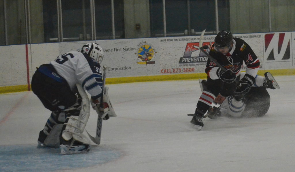 Matt Greyeyes of the HBC Havoc gets upended as he moves in on DCL Jets goaltender Mike Roesch during the A division final of the Yellowknife Oldtimers Wrap-Up Tournament at the Multiplex on Sunday. James McCarthy/NNSL photo 