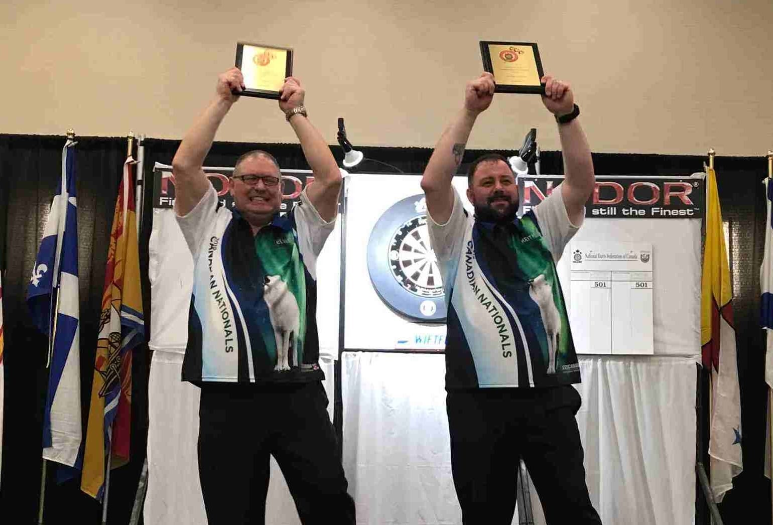 Elvis Beaudoin, left, and Keith Way hoist the champions plaques after winning the mens doubles title at the Adult National Darts Championships in Saskatoon in 2019. It was the first national title ever in darts for the NWT. photo courtesy of Sheh Murillo