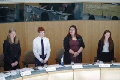 Emma Willoughby, left, representing Great Slave, Aidan Allan representing Yellowknife South, Myha Martin representing Inuvik Twin Lakes and Lisa Boutilier representing Hay River South stand during a vote for a motion to train teachers across the territory on youth mental health on Thursday, May 11 at the Government of the Northwest Territories legislative assembly. Emelie Peacock/NNSL Photo