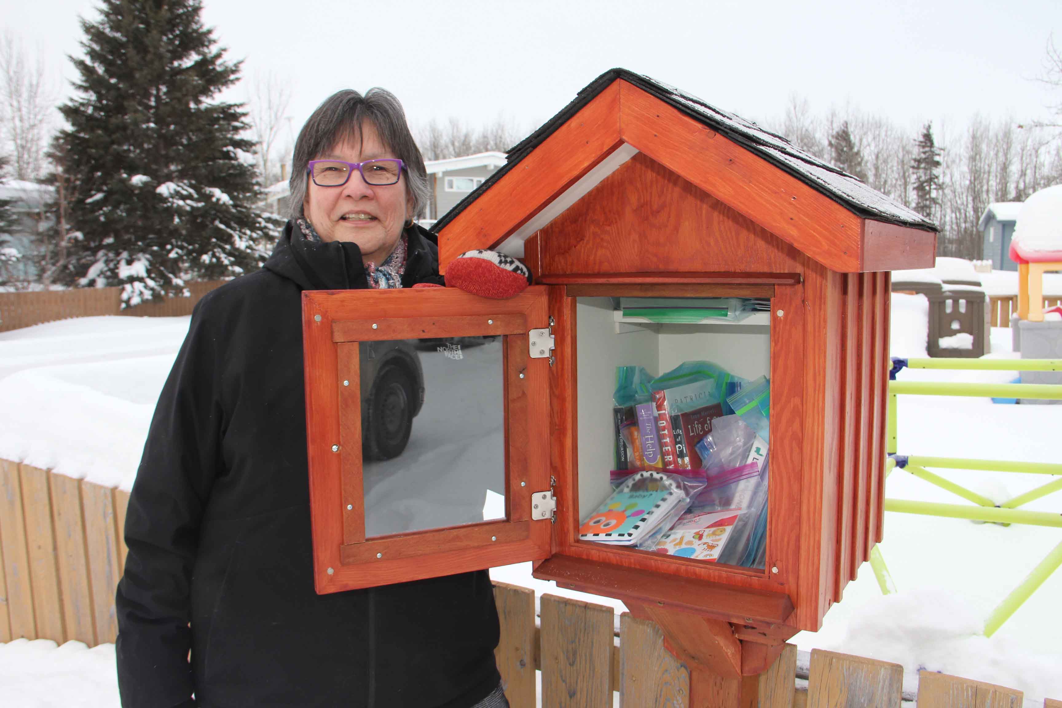 Brenda Hall, the executive director of Growing Together, stands next to the Growing Together Family Library – an outdoor box where people can pick up books at any time. Paul Bickford/ºÚÁϳԹÏÍø photo