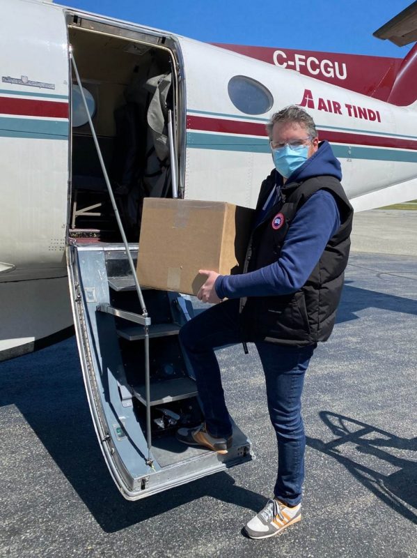 A GNWT employee carries a box of Pfizer-BioNTech vaccines from a flight that brought the doses to Yellowknife on May 4. GNWT image