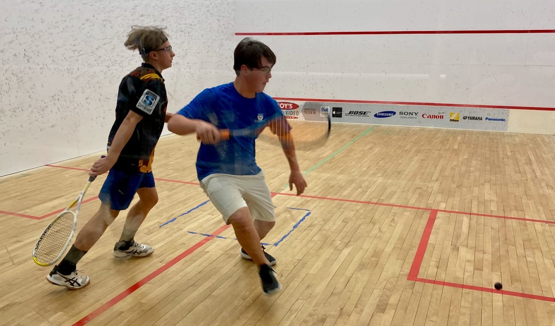 Carter Robertson, right, gets set to return a shot as Loic Hipfner tries to avoid getting in his way during the A division final of the NWT Junior Squash Championships at the Racquet Club on Sunday. photo courtesy of Jeff Hipfner