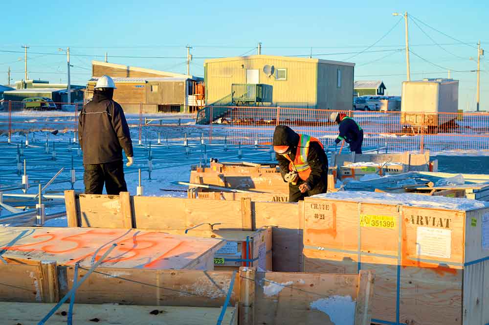 Construction workers open crates of supplies to build new homes in Arviat in October. Twenty units are scheduled to go up during the 2019-2020 construction season. photo courtesy of Nunavut Housing Corporation