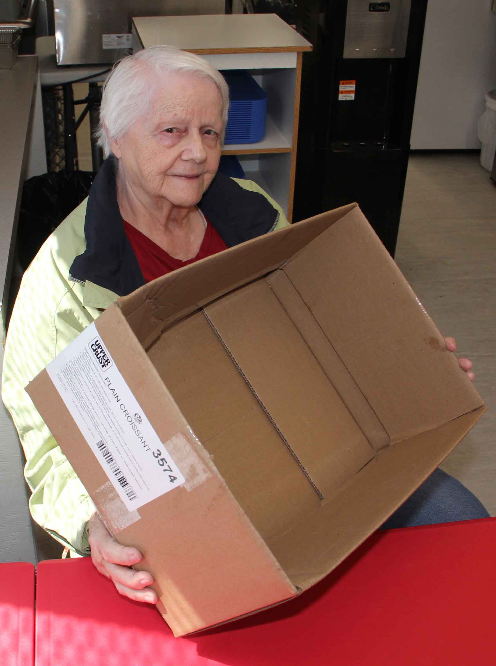 Betty Robinson, an honourary board member of the Hay River Soup Kitchen, holds an empty box that would normally become a hamper filled with food for some needy individual or family. Because of higher demand for food and rising prices, the Soup Kitchen has decided to just continue offering lunches three times a week for the foreseeable future. Paul Bickford/NNSL photo