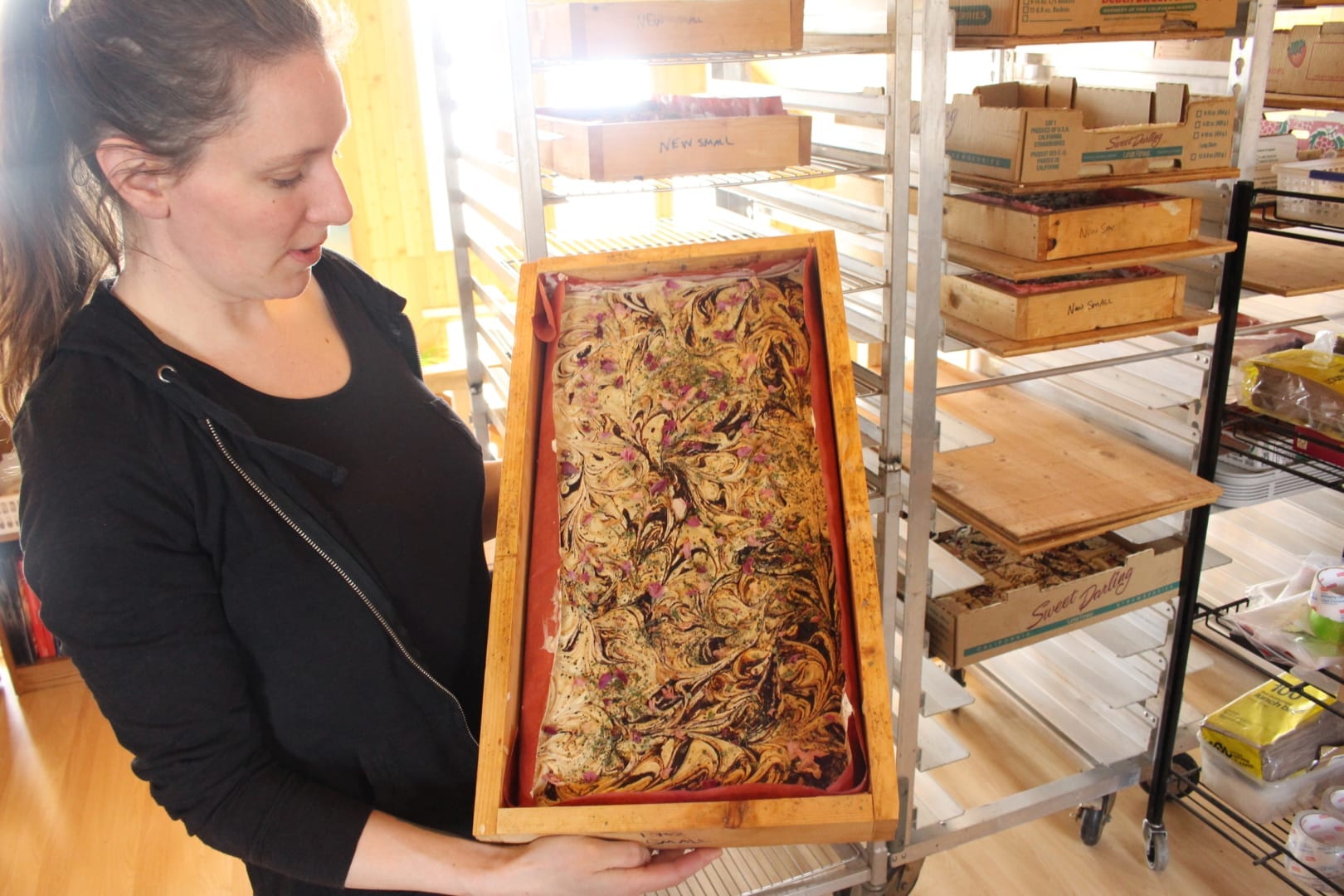 Amy Maund showing a tray of natural soaps infused with harvested vegetation from the NWT. Maund makes a half dozen different kinds of natural soaps, which are a small portion of Laughing Lichen's complete product line. Brett McGarry NNSL/Photo