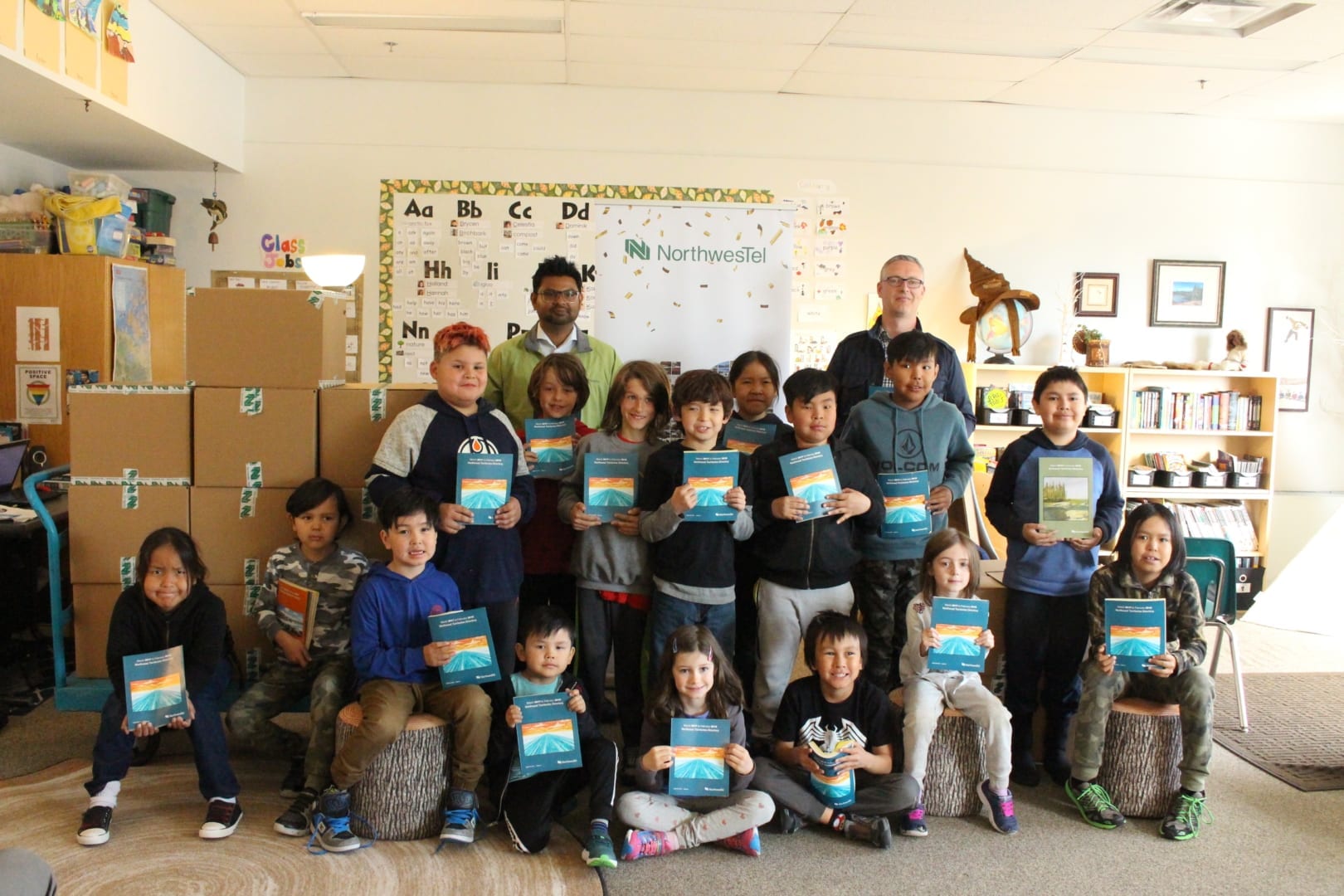 Imran Khan, back left, director with NorthwesTel and John MacDonald, back right, assistant deputy Minister of Education, Culture and Employment, awarded Mildred Hall School with the Emerald Award on Thursday for their efforts in phone book recycling. Back row, from the left, Dominik Mandeville, Matias Gannon, Koray Gannon, Kaylem Lafferty-Lermo, Lawson Liske-Nayally, Chace Mantla, Darin Catholique. Front row, from the left, Taveon Liske-Nayally, Ry'den Kakfwi Lennie, Kurtis Kimisana, Brycen Apples, Holland Van Overliw, Kaize Roach-Ashoona, Celestia O'Brien, Logan Neill-Sudlovenick. Brett McGarry / NNSL photo