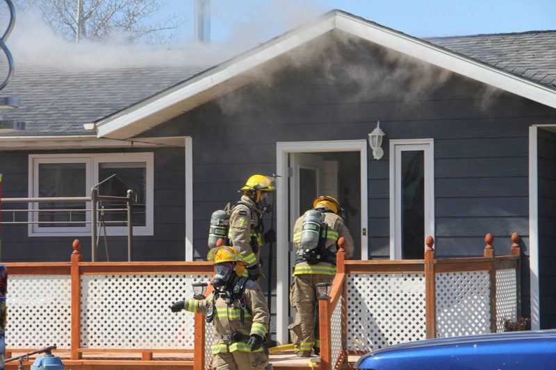                           Firefighters enter a house on Hay River’s McBryan Drive while fighting a fire in the attic and roof on May 25. Paul Bickford/ϳԹ photo          