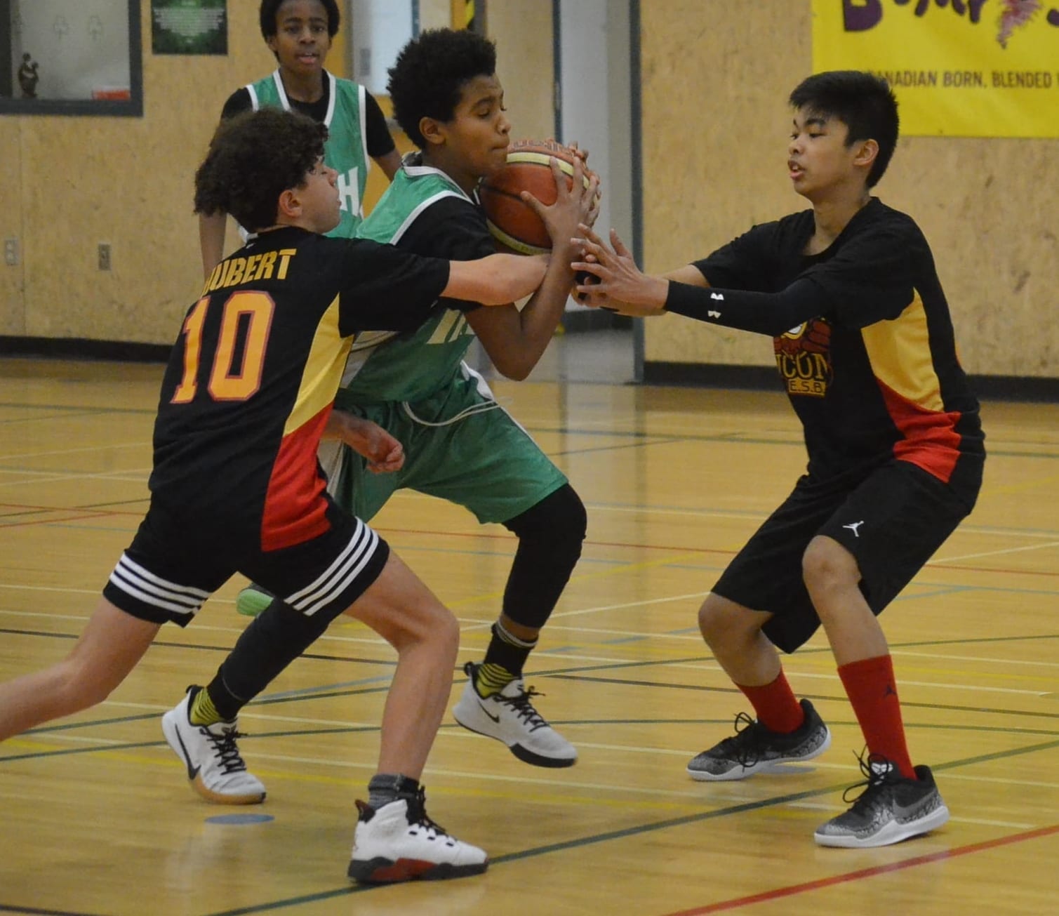 Francesco Stefanos of St. Pat's drives the lane against two defenders from Hay River's Ecole Boreale during Grade 8 boys playoff action in the Junior Cager basketball tournament at St. Pat's Gymnasium on Sunday. James McCarthy/窪蹋勛圖厙 photo