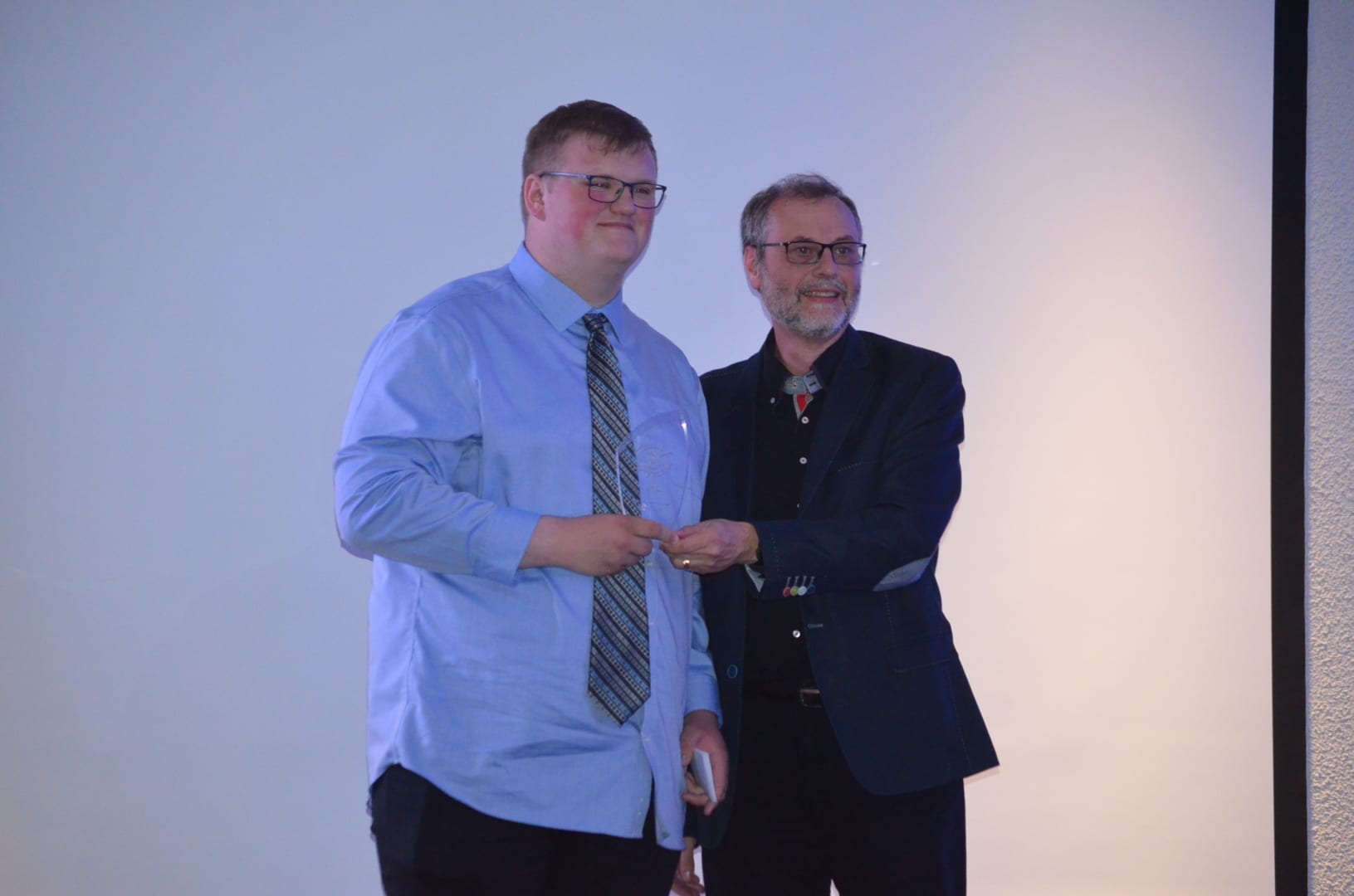 Wilson Elliot, left, receives the Junior Male Athlete of the Year Award from Glenn Tait, a member of the Sport North board of directors during the Sport North Awards at the Explorer Hotel on Saturday. James McCarthy/窪蹋勛圖厙 photo