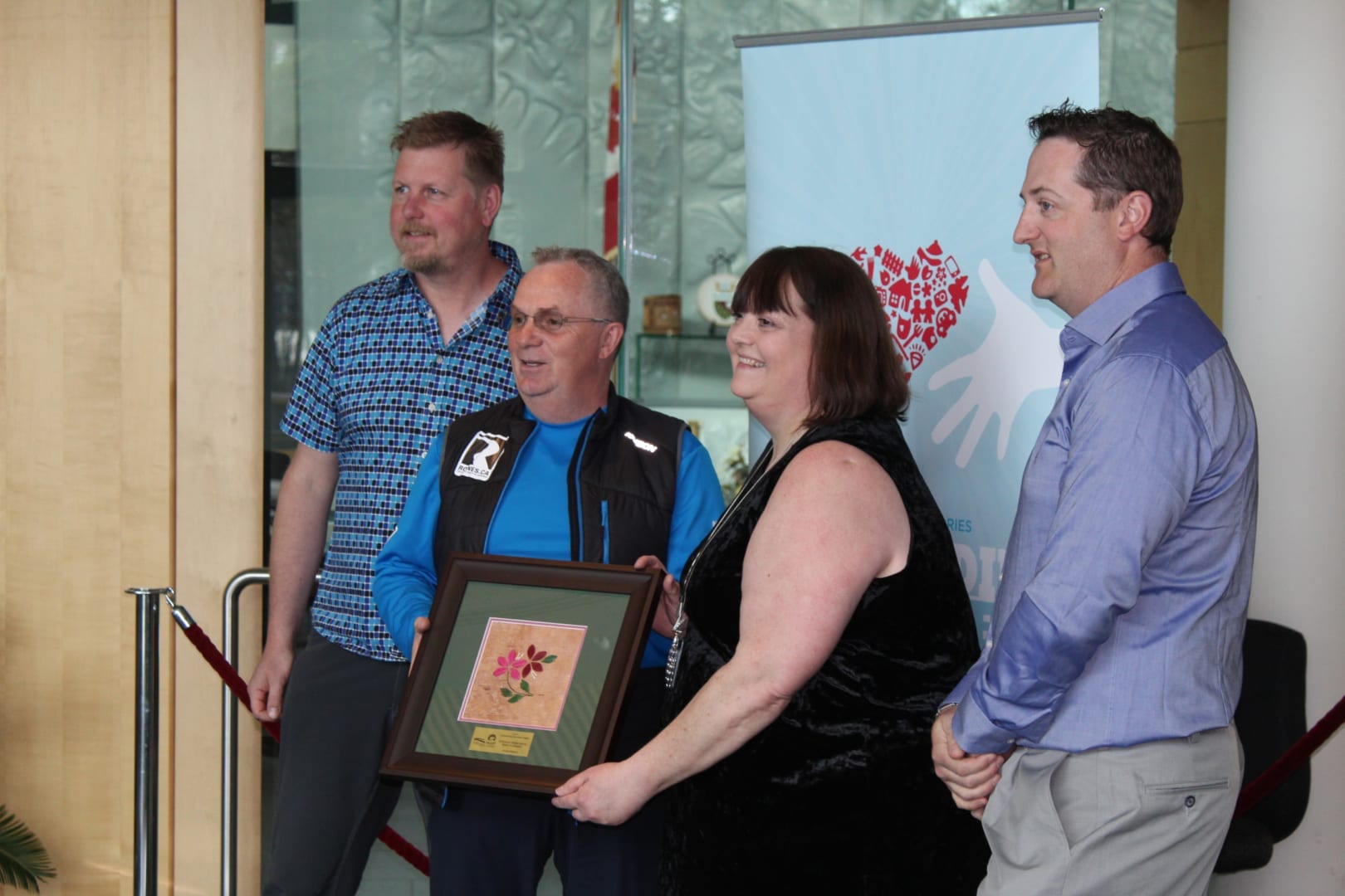 The board of the 2018 South Slave Arctic Winter Games was recognized on May 24 in Yellowknife with an Outstanding Volunteer Award from the GNWT. At the presentation were, left to right, Fort Smith’s Kevin Smith, the vice-president of the board; Greg Rowe, president; Eleanor Young, deputy minister of the Department of Municipal and Community Affairs, making the presentation of a framed porcupine quill picture; and director Jason Coakwell.  NNSL file photo 