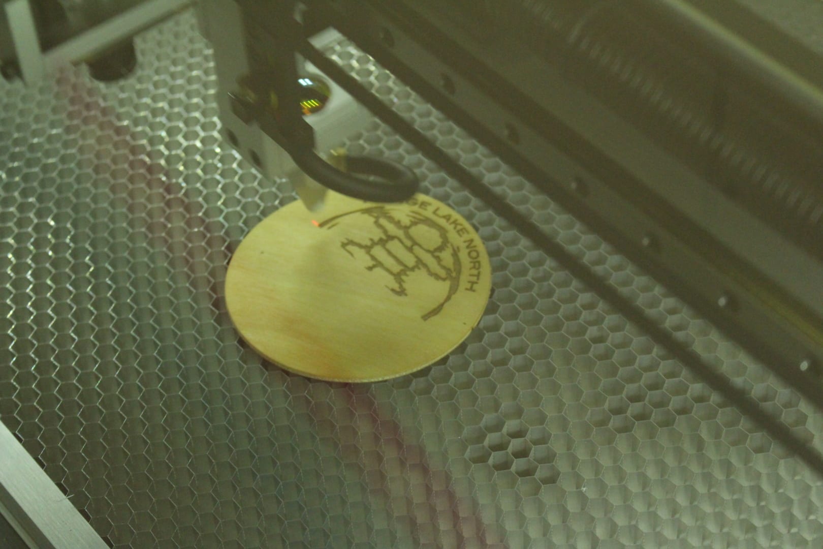 Brett McGarry/ NNSL Photo. Range Lake North Schools new $8,000 Dremel laser cutter in action, engraving the school logo into a wooden coaster.