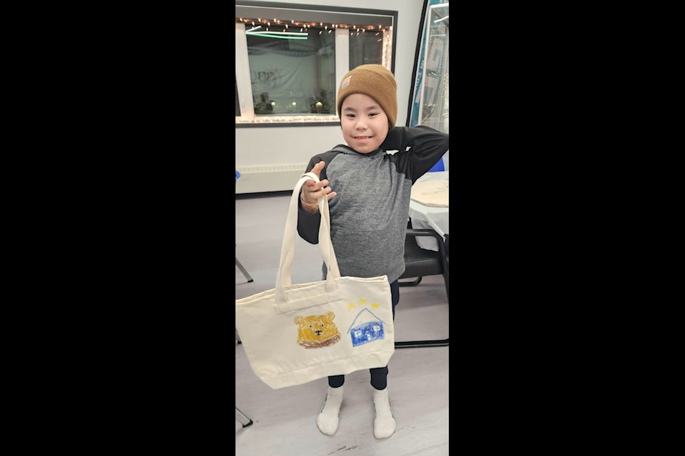 Memphis Pascal shows off a bag he made during craft night.