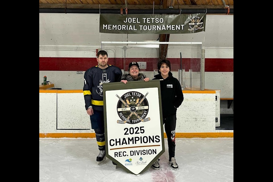 From left, Curtis Macdonald, Beverly Chepelsky Tetso and Avery Tetso stand in front of the banner for the first Joel Tetso Memorial Hockey Tournament in Fort Smith. Joel was one of the victims of last year's tragic plane crash near the community. Beverly is his widow, and Avery is his son. Curtis was the crash's lone survivor. Photo courtesy of Dana Fergusson