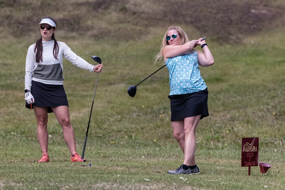 Kelsey Gill, left, admires the drive of Christy Schwartz during their round of the Hockey NWT fundraising tournament at the Hay River Golf Course on July 5. Photo courtesy of Thorsten Gohl