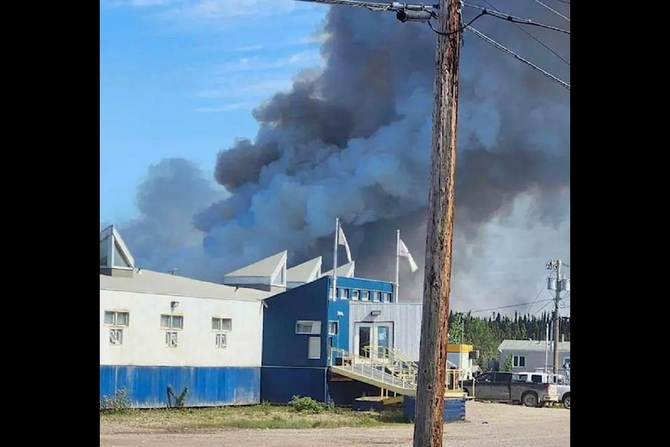 Smoke rises from behind a building in Fort Good Hope, where an evacuation was called by Chief Collin Pierrot and the community's council on Saturday afternoon. Photo courtesy of Facebook