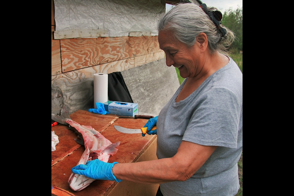 Elder Grace Blake demonstrates the finer points of cleaning a fish.
Photo courtesy Lawrence Norbert
