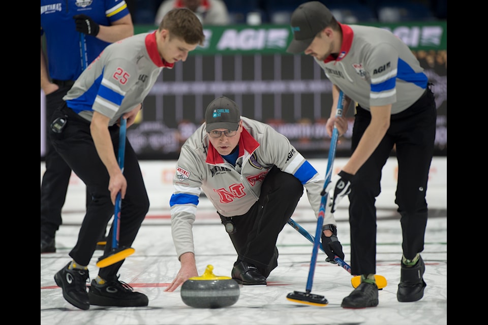 Adam Naugler, left, and Eric Preston, right, prepare to brush Aaron Bartling's delivery during action at the Montana's Brier in Kelowna, B.C., on Sunday. Curling Canada/Michael Burns photo
