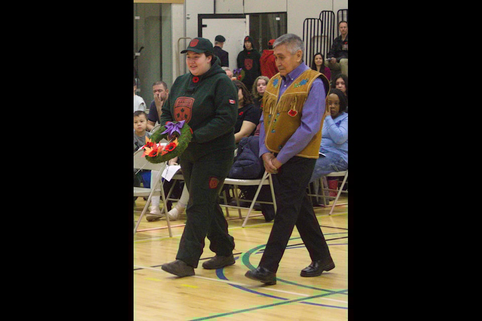 Canadian Ranger Alaina Joe-Beaudin and Elder Neil Pascal lay a wreath on behalf of the Gwich'in Tribal Council.