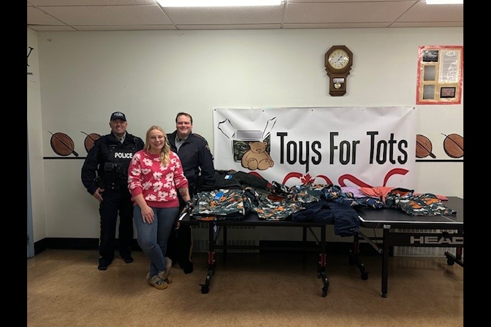 RCMP Sgt. Michel Mignon, Larissa Emmons, and Const. Jason Emmons distribute winter jackets to students at Moose Kerr School in Aklavik. Photo courtesy of RCMP