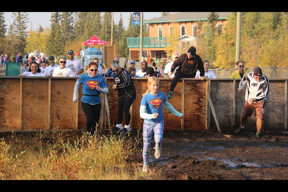 And they’re off! Participants run towards and climb over the first obstacle in the CIBC Mud Run on Saturday at the Yk Ski Club. Jill Westerman/NNSL photo
