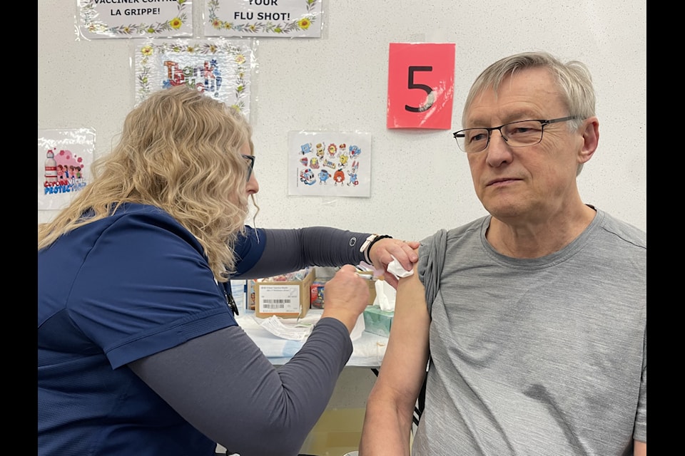 Janie Neudorf, left, gives Andre Corriveau one of his vaccines.
